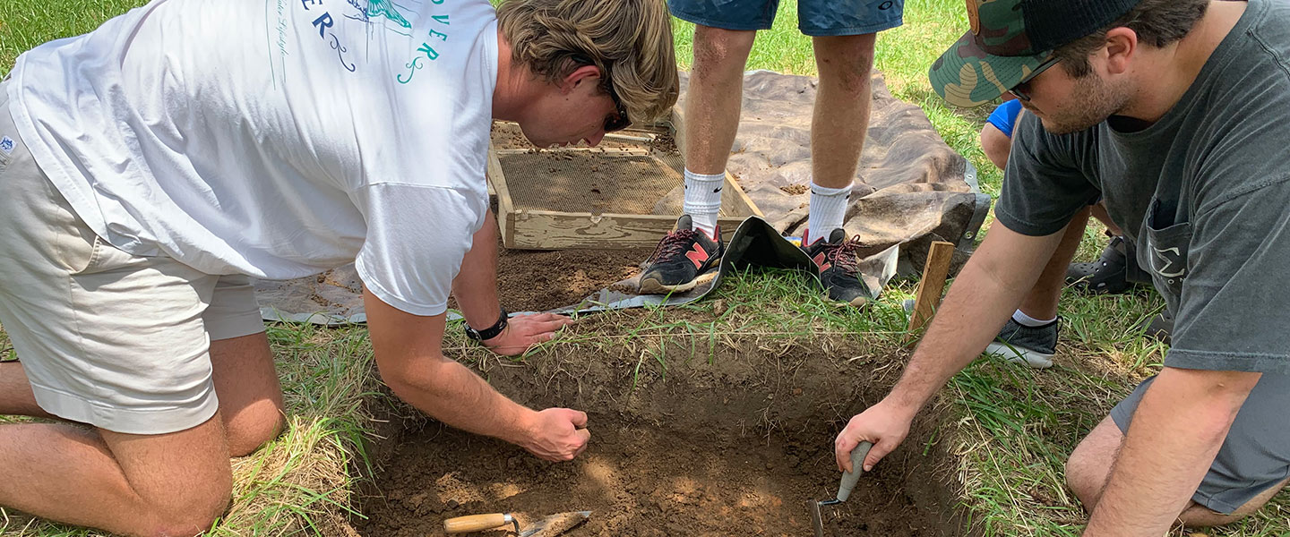 Students digging in the dirt at a historic archaeology site