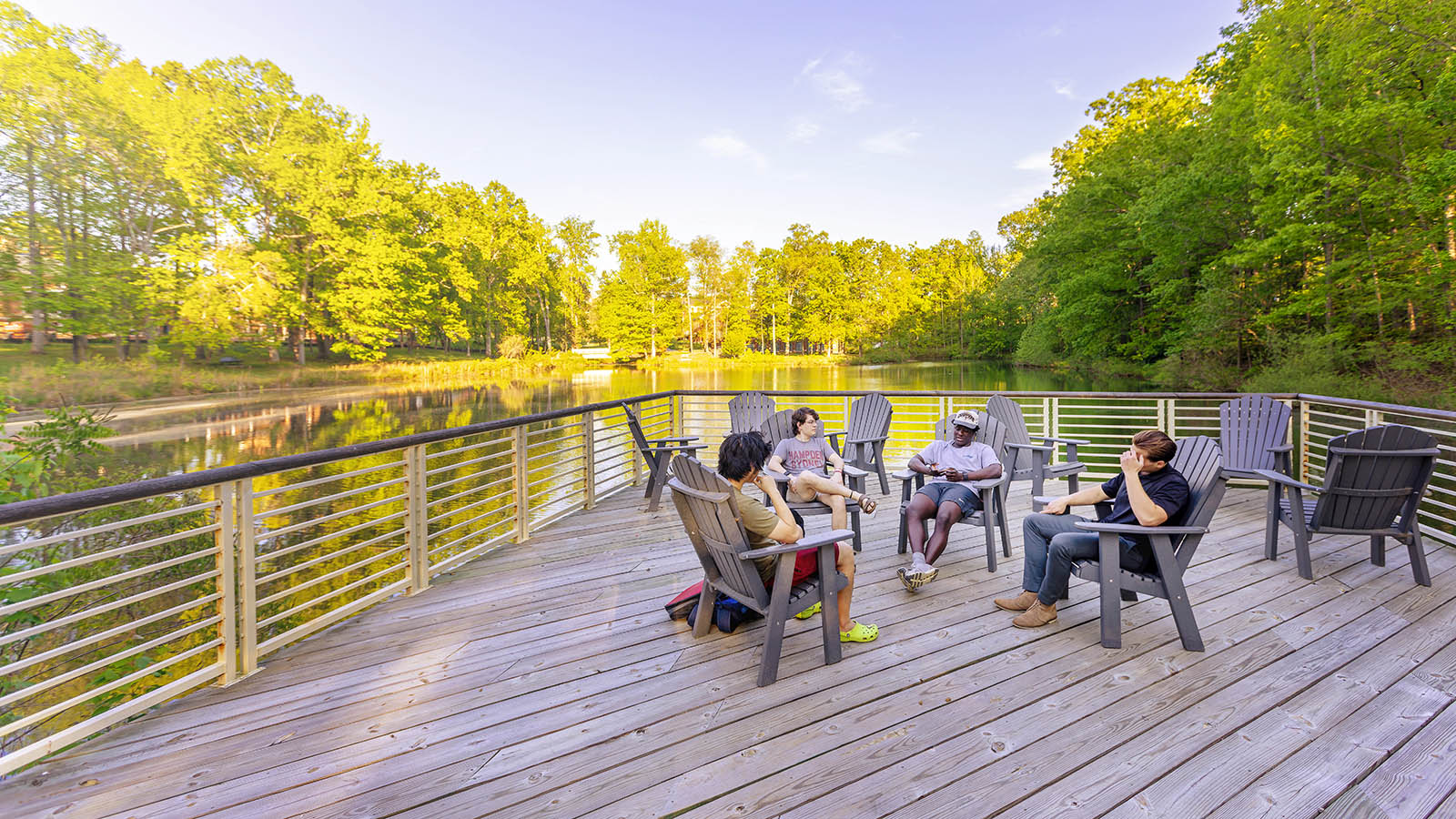 Students sitting on a dock on Lake Chalgrove at Hampden-Sydney College