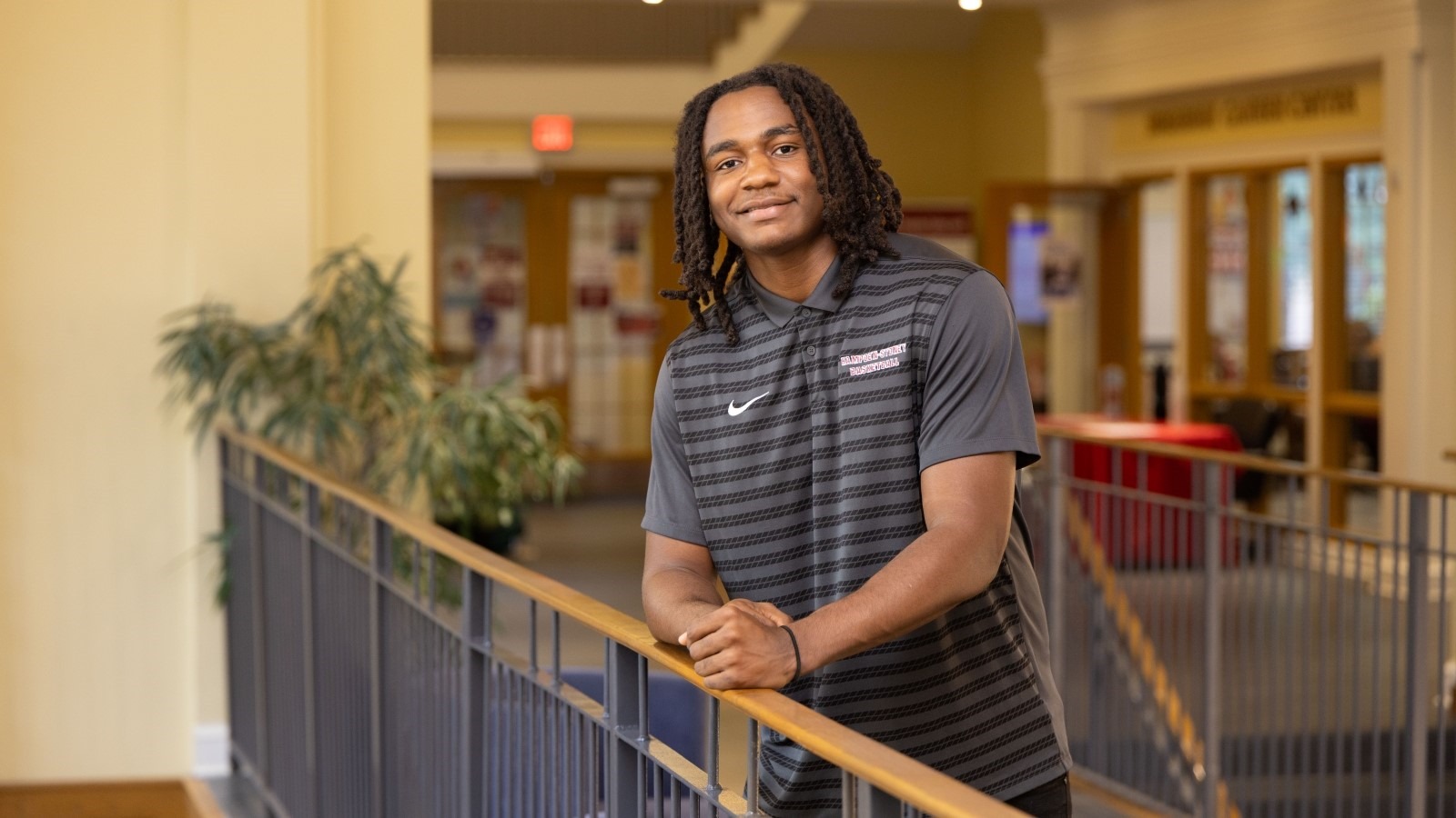 Student Asa Williams standing at the top of the student center stairs