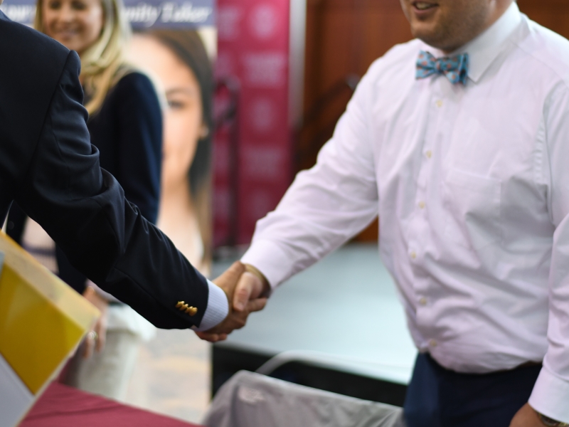 a close-up of two men extending a handshake