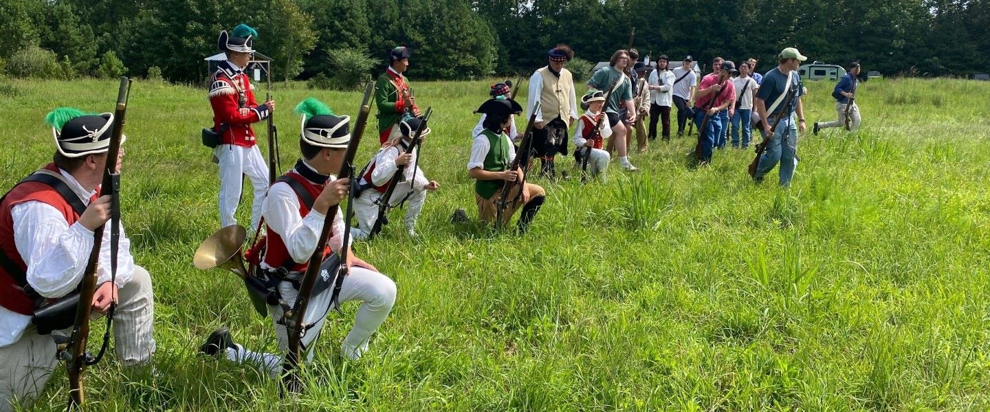 students in historic dress standing in a field