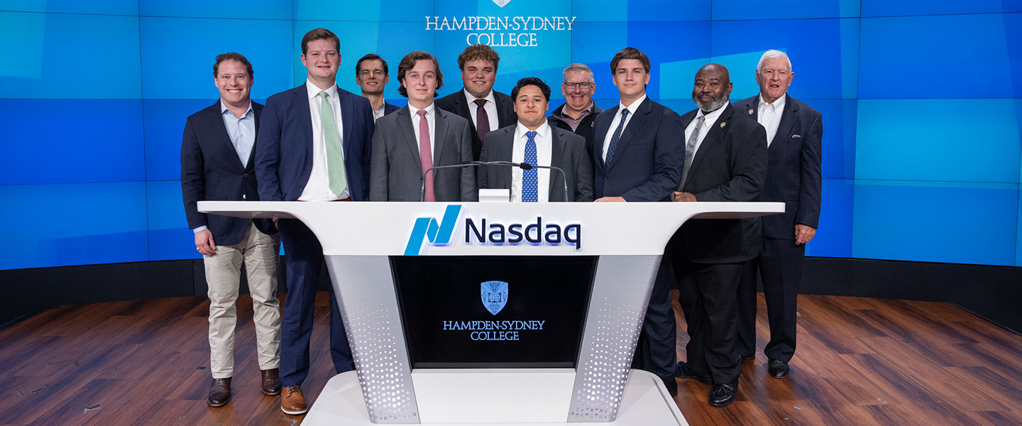 Students in suits standing around the Nasdaq call sign table