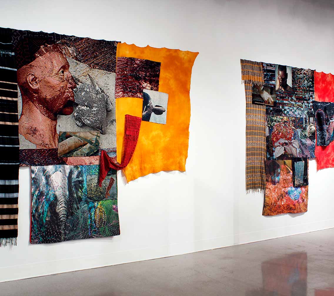 an art exhibit featuring a tapestry with African men