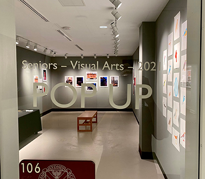 A photo looking through the glass of the student pop-up exhibit in the Gallery at H-SC