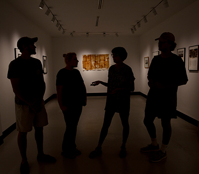 people standing in the art gallery in silhouette