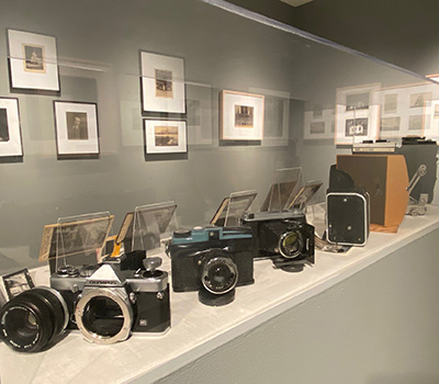 vintage cameras on display in a gray art gallery