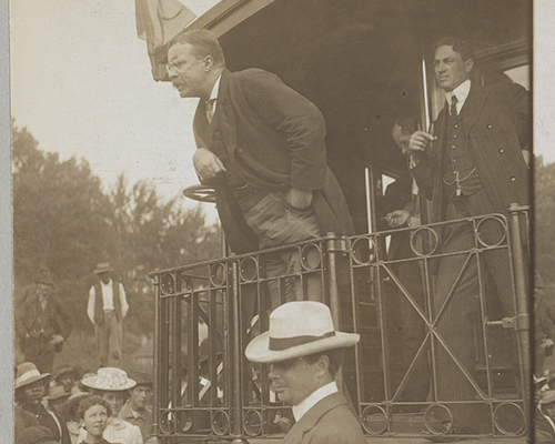 Teddy Roosevelt speaking t the back of a railroad car, 1907.
