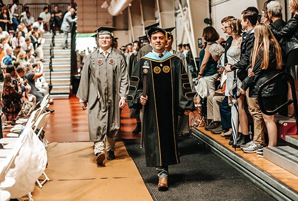 Class of 2022, in full regalia, processes in a line during commencement