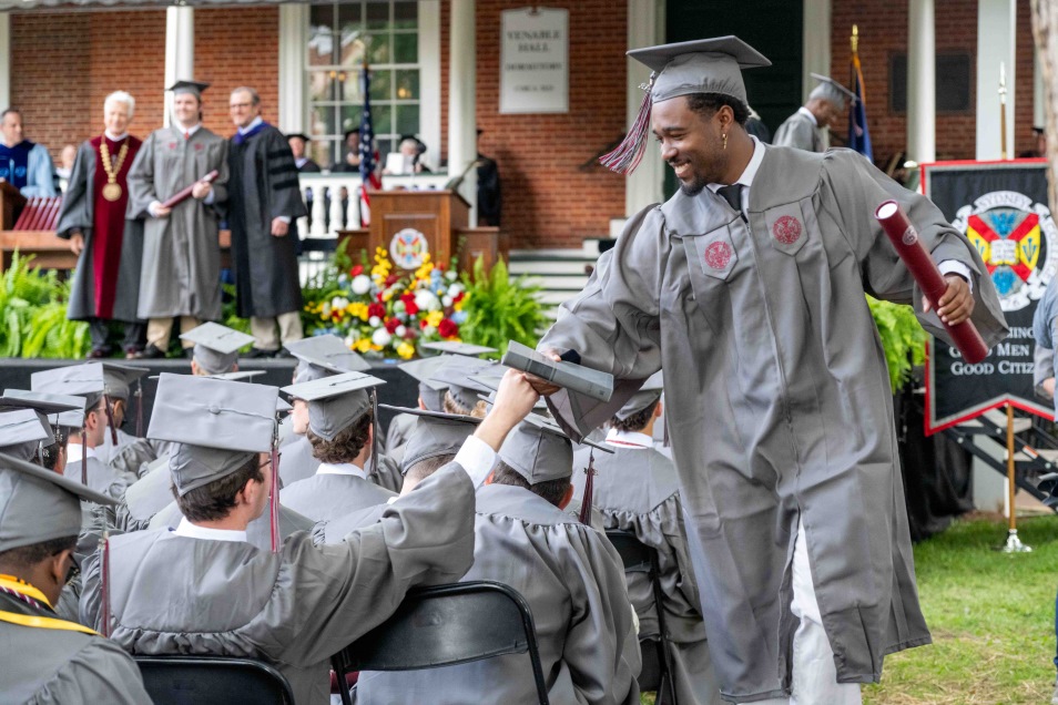 students fist bumping at commencement