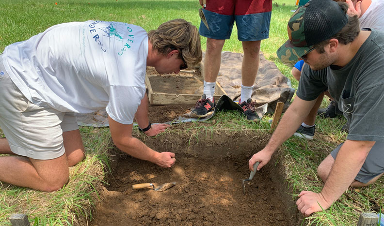 students digging in the dirt on an archaeological site