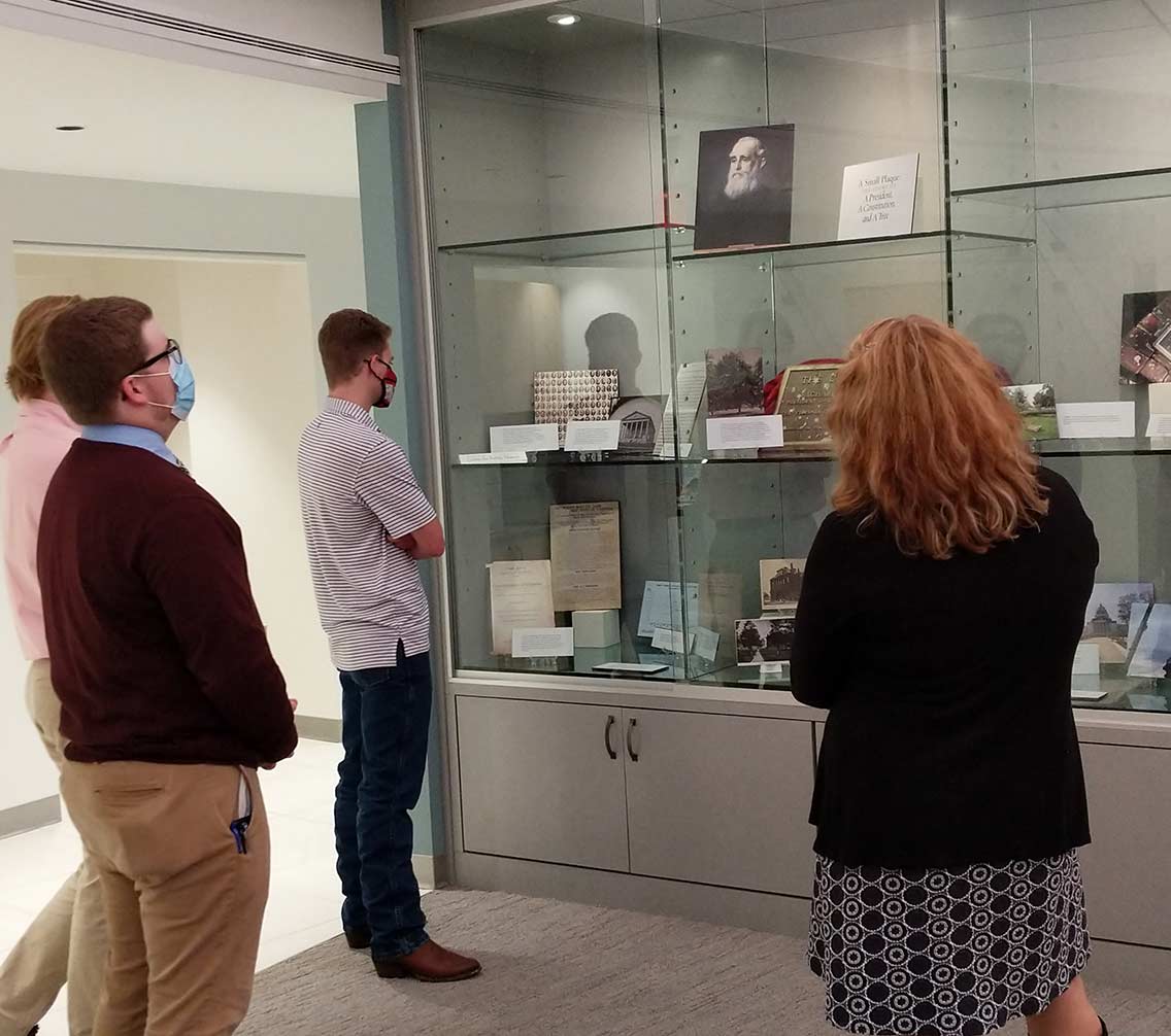 student and professor examine a public history display
