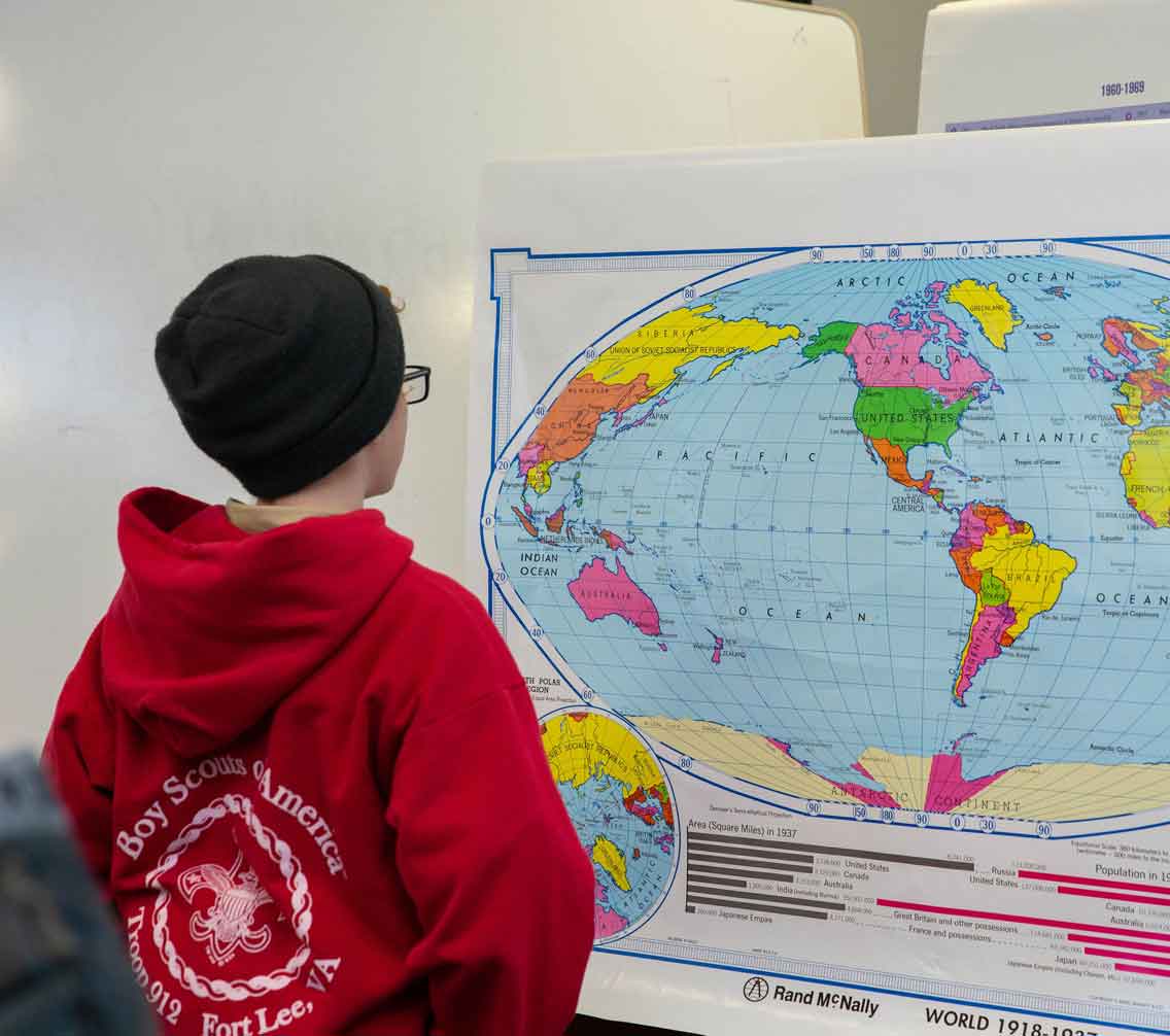 Young boy looking at a world map