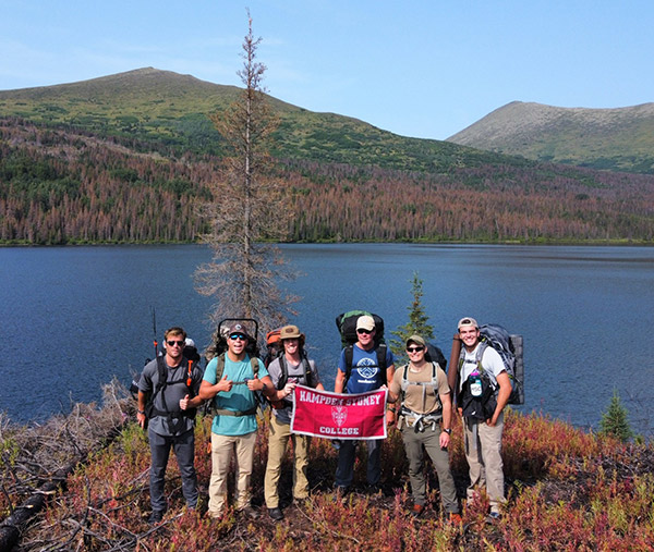 a group of Hampden-sydney student backpackers standing next to an Alaskan lake