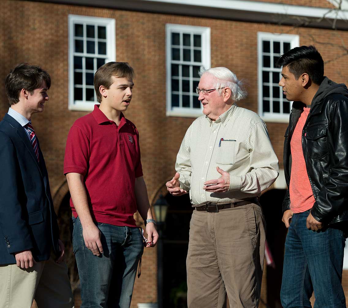 Dr Herb Sipe talking with students outside Gilmer Hall