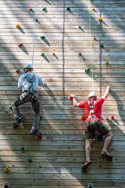 students ascending an outdoor climbing wall