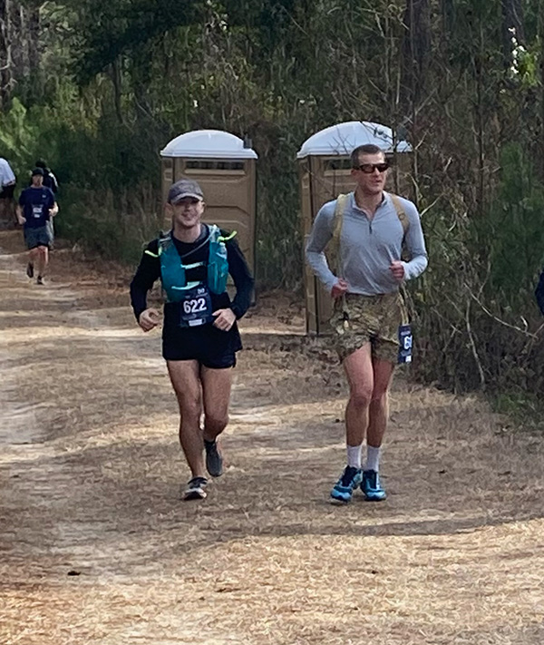 Carson Mann ’25, Greyson Hurley ’24, and James Gilbert ’23 running on a path during  an ultramarathon