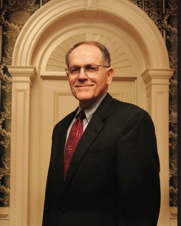 Dr. Walter Bortz, former President of Hampden-Sydney College standing for his headshot in front of a doorway