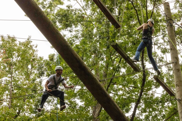 Students balancing in the trees at an outdoor ropes course