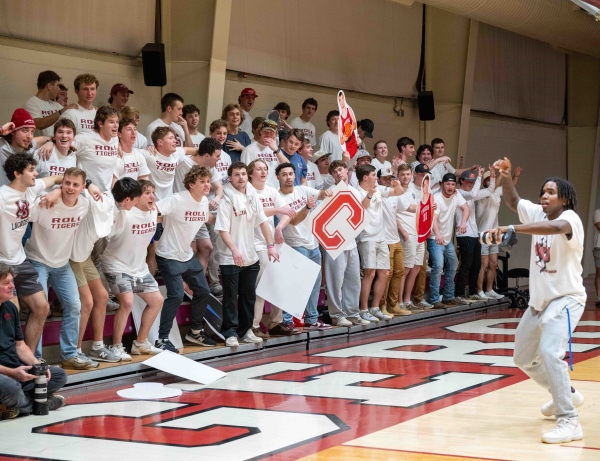 Alex Fitz-Hugh leading friends in a cheer at a basketball game