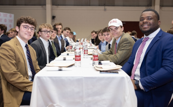 Students sitting at a long dinner table