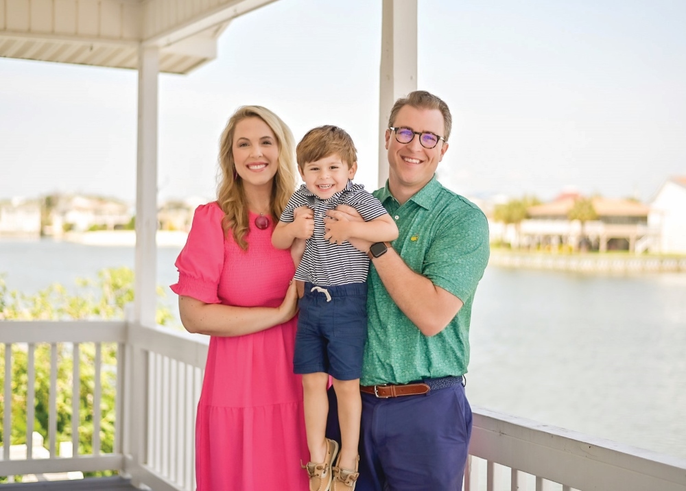 Scott Anderson and his wife and child smiling on their porch