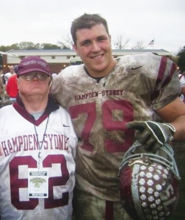 Scott Anderson '10 in football uniform standing with Shorty Simms