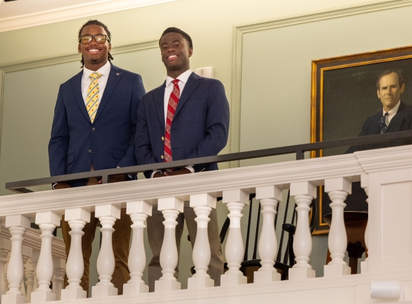 Alex Fist-Hugh in coat and tie standing with a friend in Venable Hall