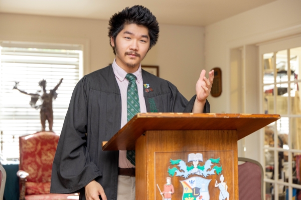 Ben Jia standing at a podium wearing a robe