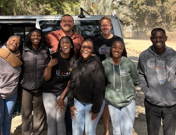 Carter Spawn smiling with a group of friends in Zimbabwe