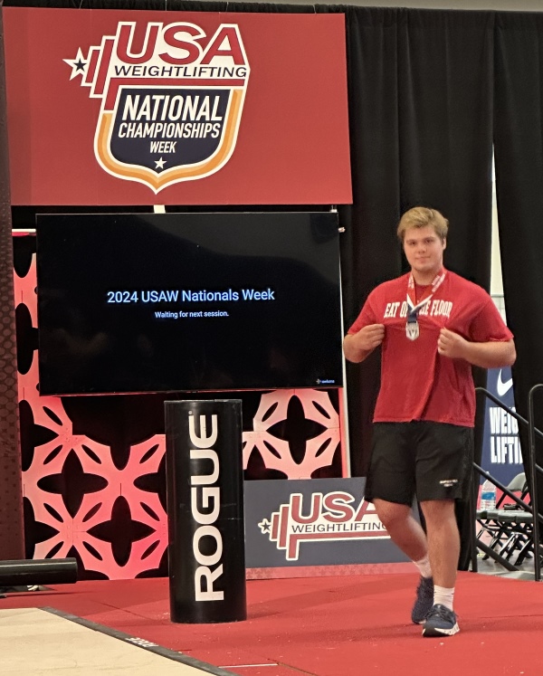 Logan Cohn '25 walking onstage at the USA Weightlifting National Championships